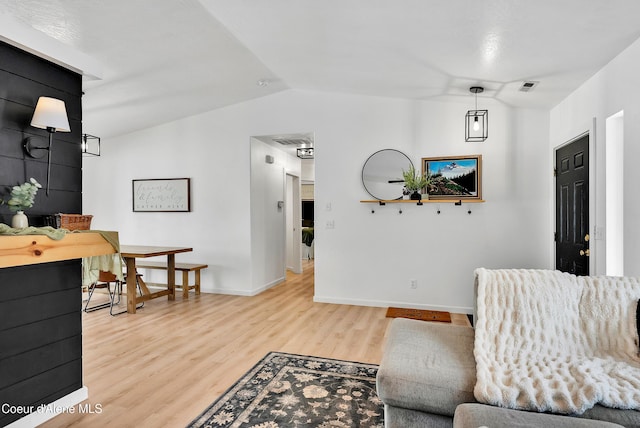 living room featuring light hardwood / wood-style flooring and vaulted ceiling