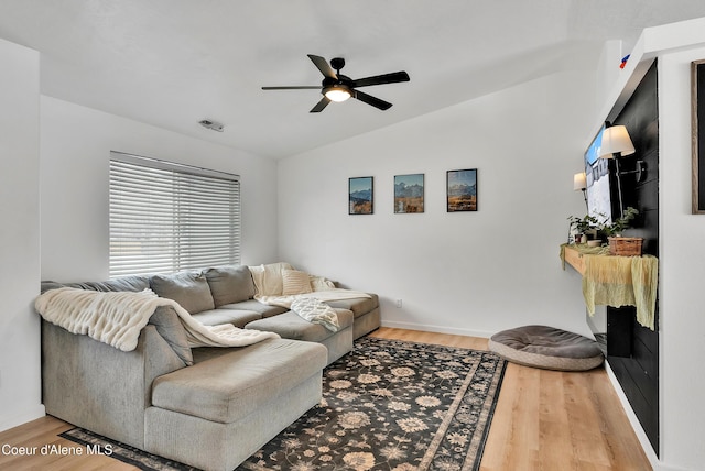 living room featuring ceiling fan, vaulted ceiling, and wood-type flooring