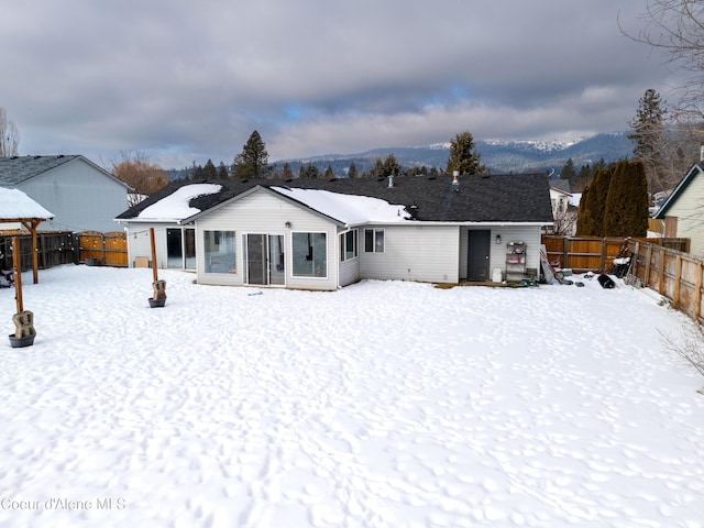 snow covered house featuring a mountain view