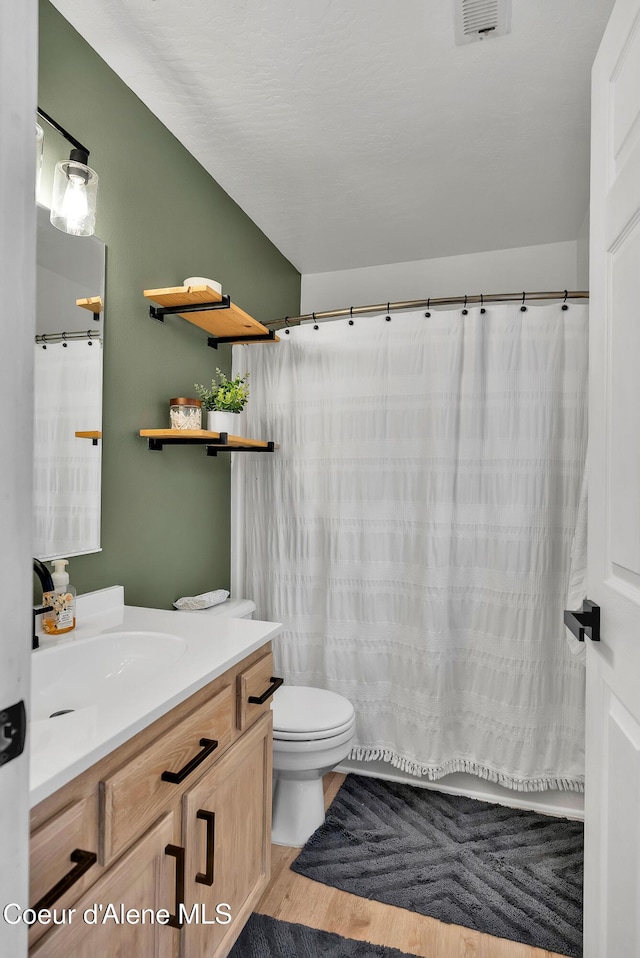 bathroom with hardwood / wood-style flooring, vanity, and toilet