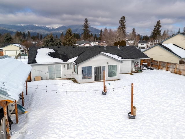 snow covered rear of property featuring a mountain view