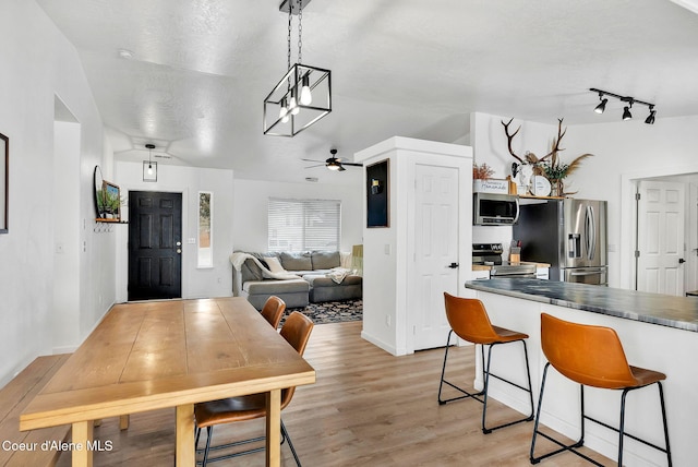 dining room with ceiling fan, a textured ceiling, and light hardwood / wood-style floors