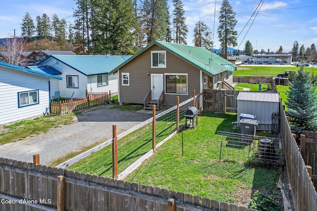 1108 Pine St, Sandpoint, ID 83864 - view of front of property featuring fence private yard, entry steps, metal roof, a front yard, and gravel driveway