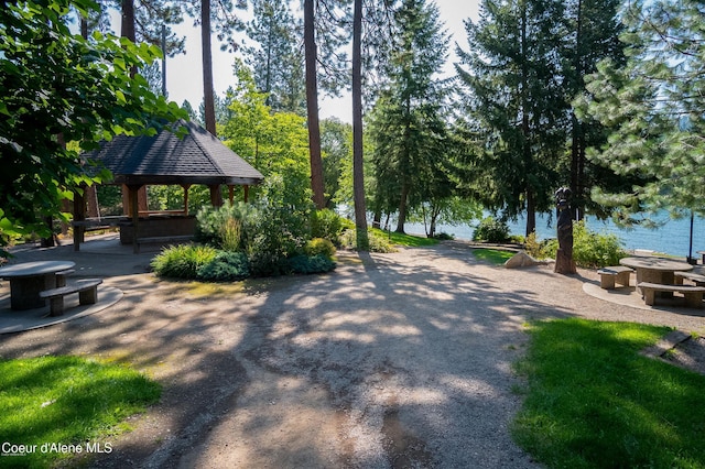 view of property's community with a water view, a patio area, and a gazebo