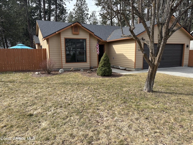 ranch-style home featuring a front yard, fence, driveway, and an attached garage