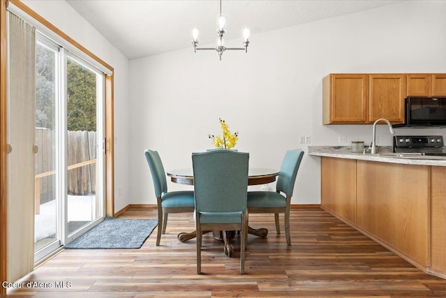 dining room featuring a chandelier, dark wood-style flooring, and baseboards