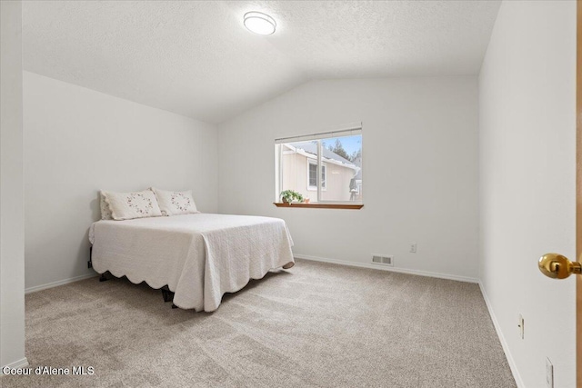 bedroom with light carpet, baseboards, visible vents, vaulted ceiling, and a textured ceiling