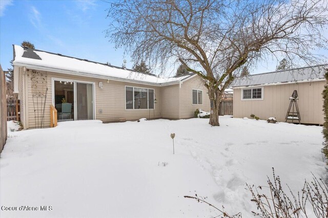 snow covered back of property with fence