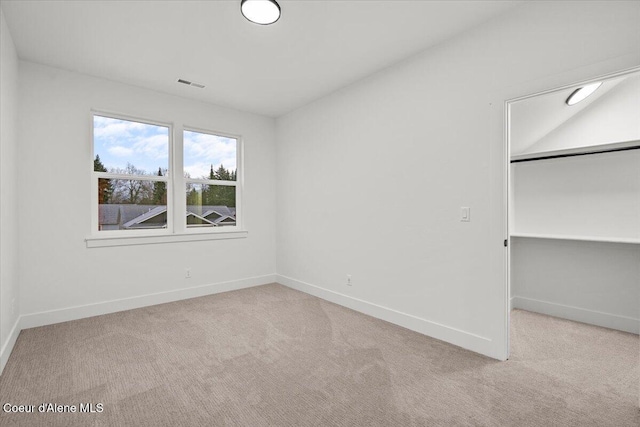 unfurnished bedroom with a closet and light colored carpet