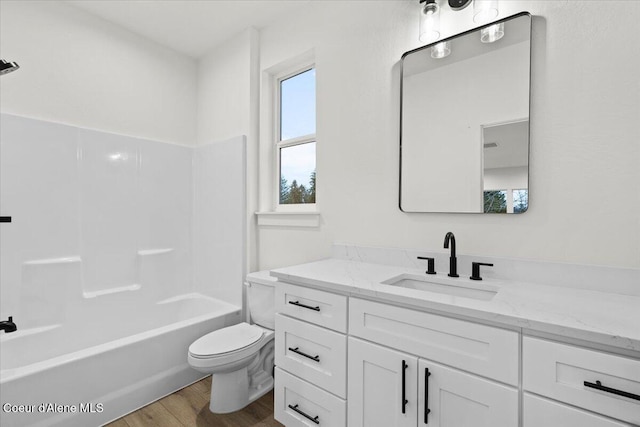 full bathroom with shower / tub combination, wood-type flooring, vanity, and toilet