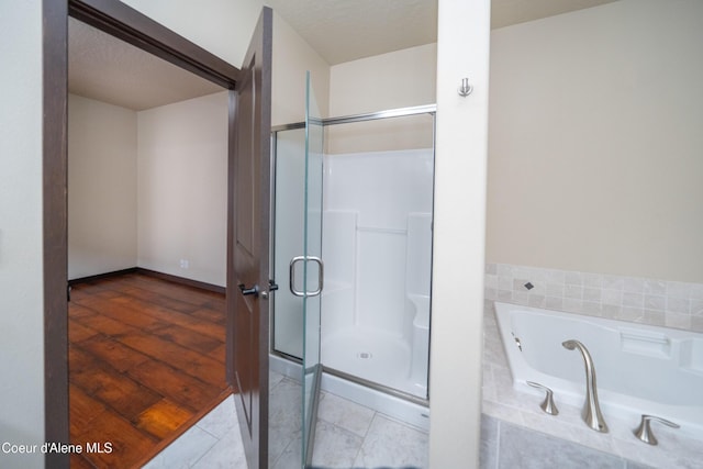 bathroom featuring a bath, a stall shower, and tile patterned flooring