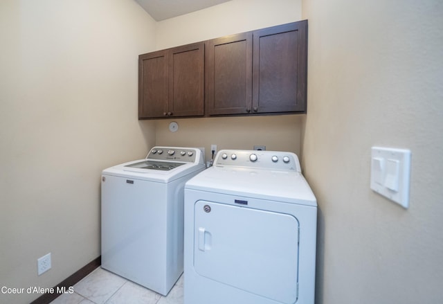 clothes washing area with washer and dryer, baseboards, and cabinet space