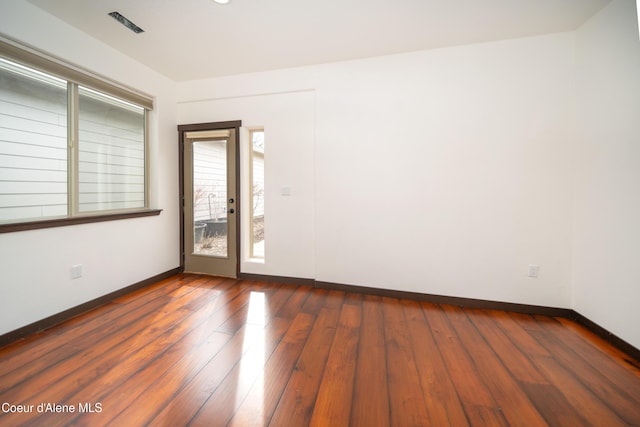 unfurnished room featuring baseboards and hardwood / wood-style floors