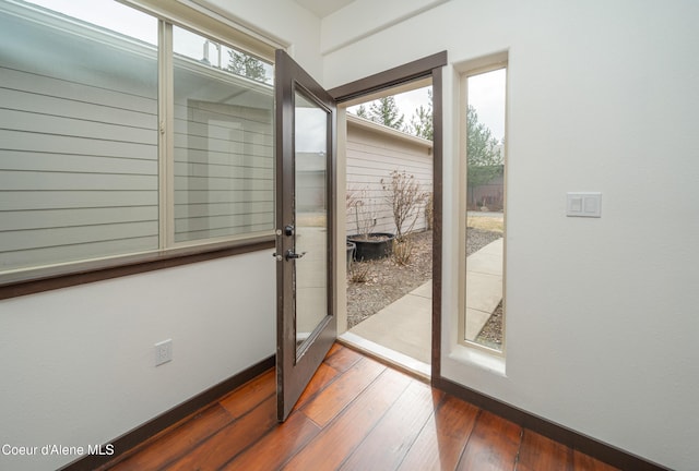 entryway with baseboards and wood-type flooring