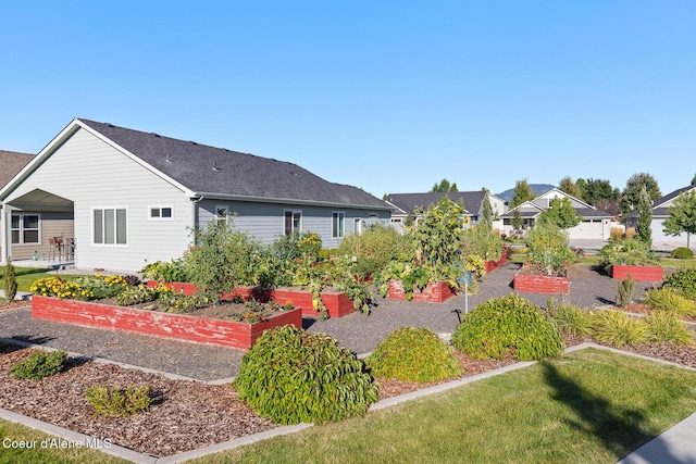 view of yard featuring a residential view and a vegetable garden