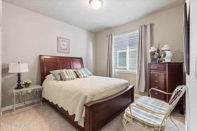 bedroom with light carpet and baseboards