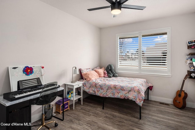 bedroom with ceiling fan, baseboards, and wood finished floors