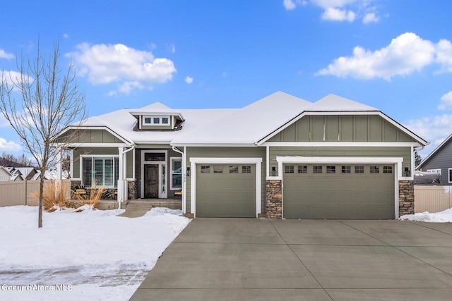 view of front of property with board and batten siding, fence, and a garage