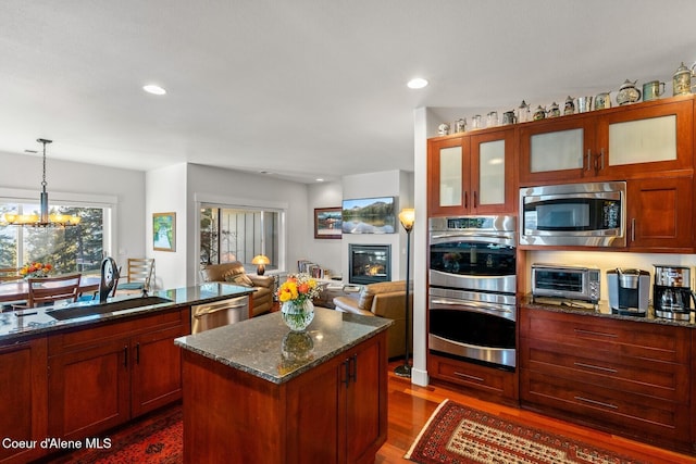 5006 S Brentwood Ln, Coeur Dalene, ID 83814 - kitchen featuring a center island, pendant lighting, stainless steel appliances, glass insert cabinets, and open floor plan