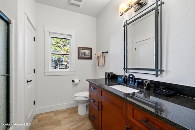 5006 S Brentwood Ln, Coeur Dalene, ID 83814 - bathroom with baseboards, visible vents, toilet, an enclosed shower, and vanity