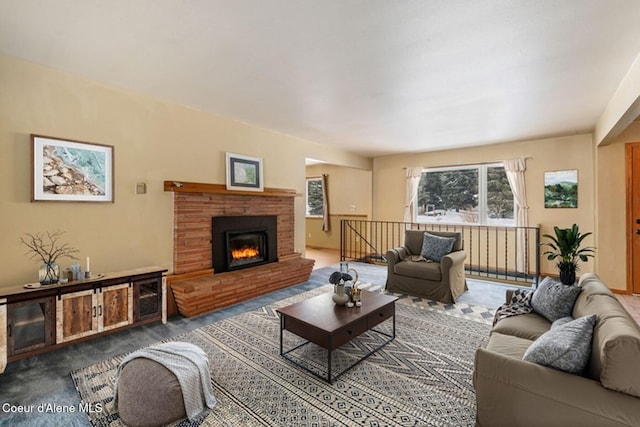 living room featuring a brick fireplace and baseboards