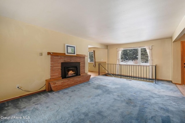 unfurnished living room with a brick fireplace, light colored carpet, and baseboards