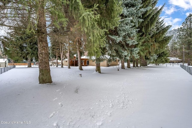 yard covered in snow with fence