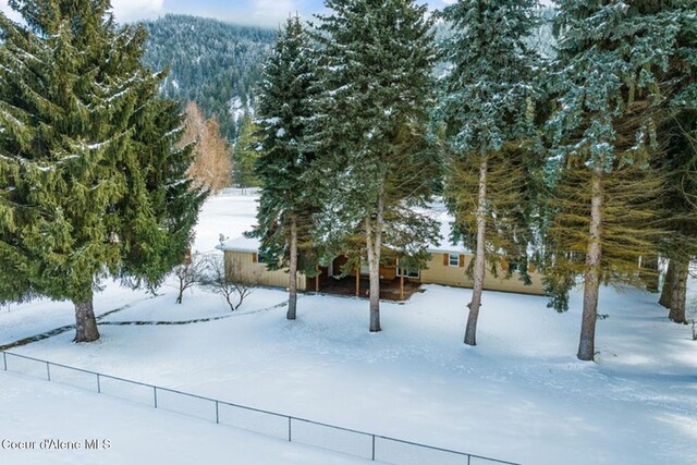 snowy yard with fence and a mountain view