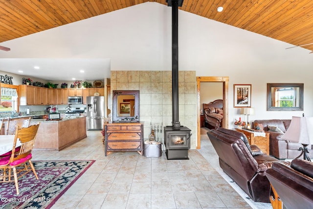 interior space featuring a wood stove, wood ceiling, high vaulted ceiling, and a wealth of natural light