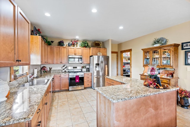 kitchen featuring recessed lighting, appliances with stainless steel finishes, a sink, and a center island