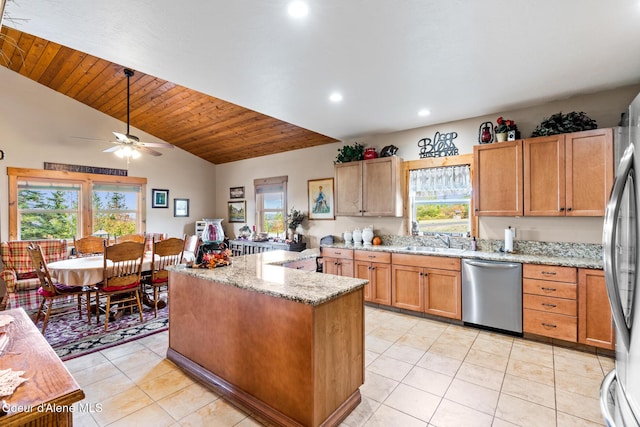 kitchen with light stone countertops, a wealth of natural light, stainless steel appliances, and a sink