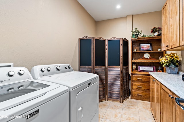 clothes washing area with cabinet space, washer and clothes dryer, and light tile patterned floors