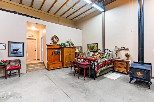 bedroom featuring a wood stove and concrete floors