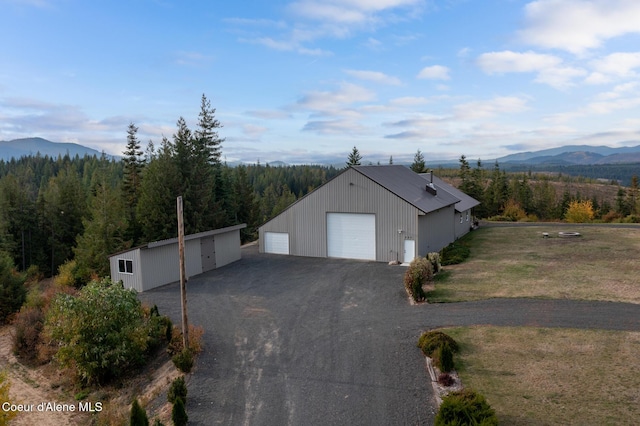 detached garage with a forest view and a mountain view