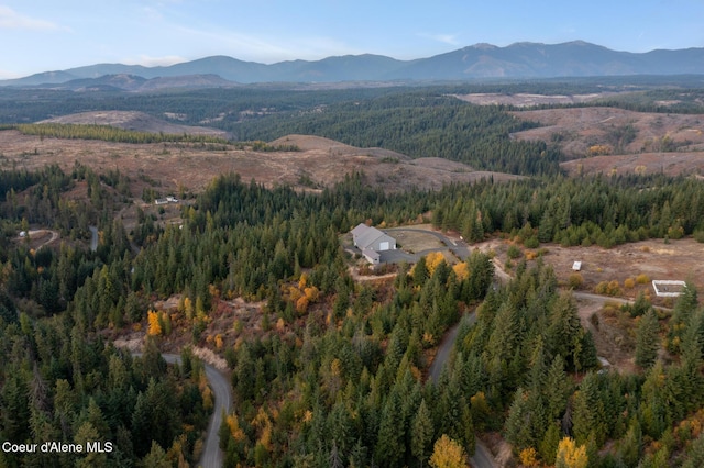 birds eye view of property featuring a forest view and a mountain view