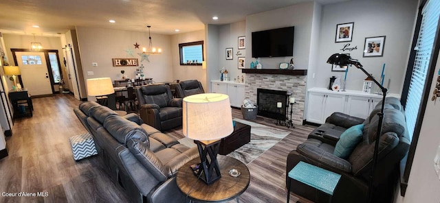 living room with recessed lighting, a notable chandelier, a fireplace, and wood finished floors