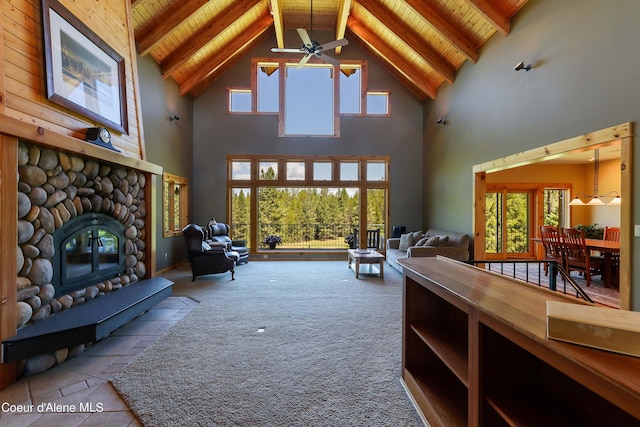 living room with vaulted ceiling with beams, wood ceiling, carpet flooring, and a fireplace