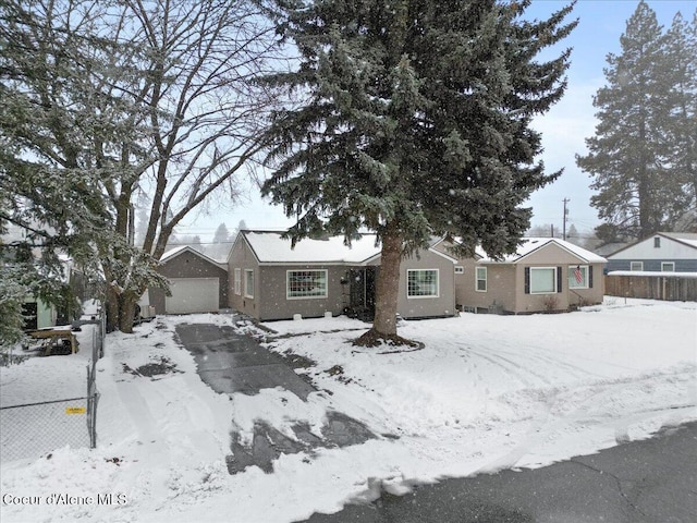 single story home with a detached garage and fence