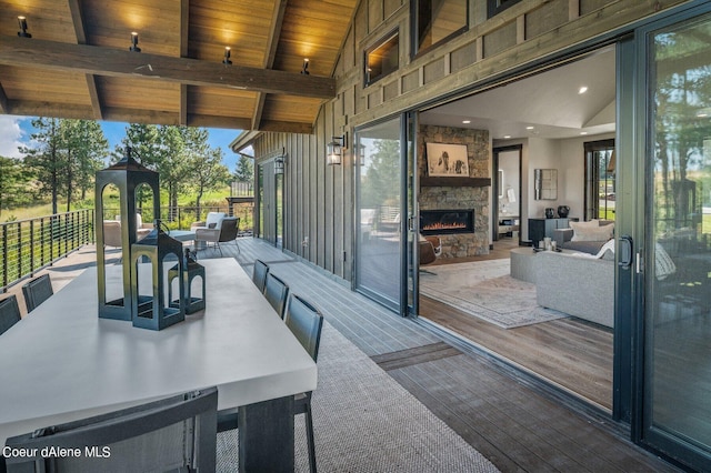 exterior space featuring an outdoor living space with a fireplace and a deck