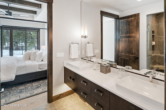 ensuite bathroom with a sink, double vanity, baseboards, and connected bathroom