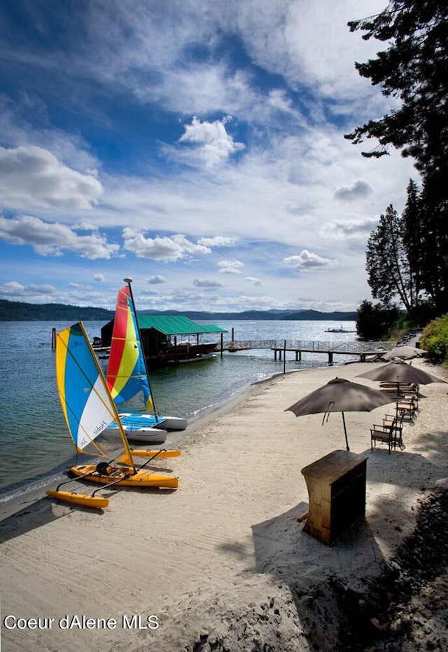 dock area with a water view and a view of the beach