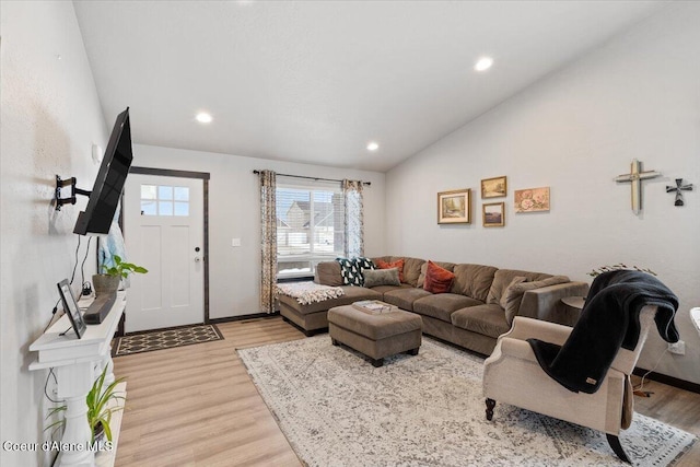 living room featuring lofted ceiling, light wood finished floors, recessed lighting, and baseboards