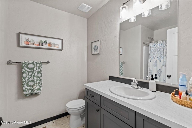 full bath with visible vents, a textured wall, vanity, and toilet