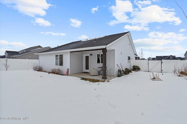 snow covered house with fence and a gate