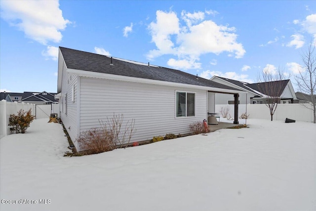 snow covered rear of property with fence