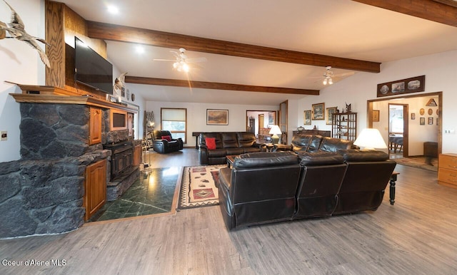 living room with a ceiling fan, beam ceiling, and wood finished floors