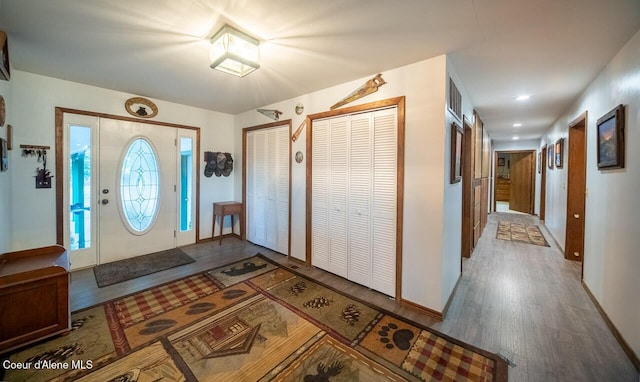 entryway with baseboards and wood finished floors