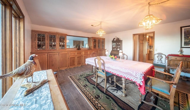 dining space with a notable chandelier and wood finished floors