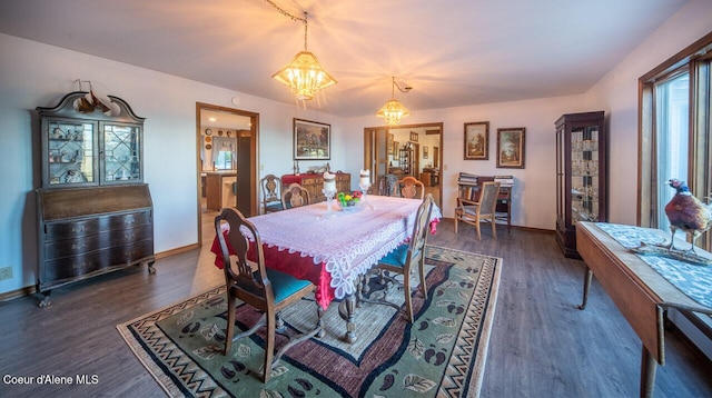 dining room with a chandelier, baseboards, and wood finished floors