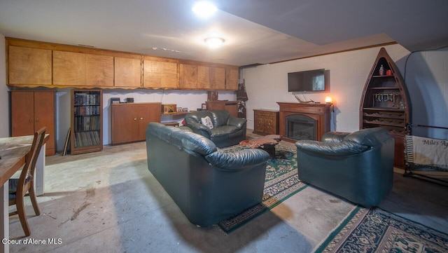 living area with unfinished concrete flooring, a fireplace, and concrete block wall